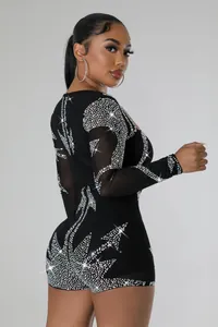 Detailansicht eines sexy schwarzen Langarm-Bodysuits mit funkelnden, aufwendigen Strassmustern