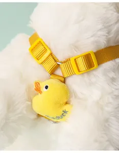 Detalle en primer plano del adorable patito de peluche y la hebilla ajustable del arnés para perros