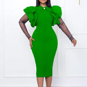 Dettaglio dell'abito verde elegante con spalle a balze e maniche in rete a pois