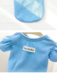 Gros plan d'un pull en tricot bleu clair pour animaux avec manches à volants et tag
