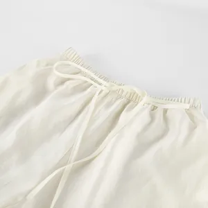 Close-up of elastic waistband and drawstring detail on off-white Tencel trousers