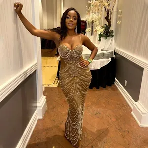 Full body view of a sexy mermaid evening gown with pearls and rhinestone details.
