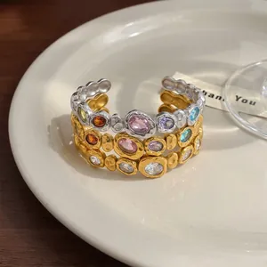 Detailed macro view of three stacked hammered texture rings featuring colorful gemstones