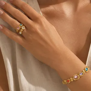 Detail of 18K gold plated titanium steel jewelry set with colorful oval stones on skin.