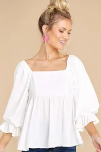 Detailed view of elegant white square neck blouse with puff sleeves and ruffled cuffs