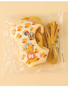 Detalle de arnés y correa para perro con diseño de patos amarillos empaquetados.