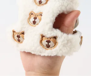 Detail view showing soft white lamb fleece texture and cute bear embroidery on dog harness