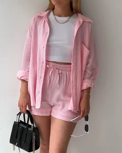 Detailansicht des rosa Baumwoll-Sets aus Hemd und Shorts mit Model-Accessoires