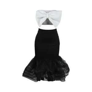 Detalle del conjunto de dos piezas con top con lazo blanco y falda de malla negra.