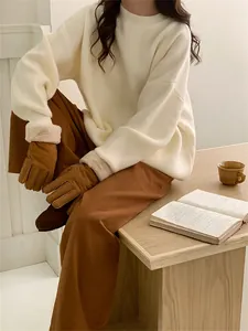 Pull en maille ample de couleur crème avec col rond présenté dans un décor de vie