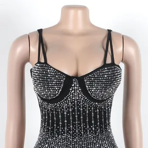 Dettaglio di un abito bodycon nero senza maniche con decorazioni in strass argentati.