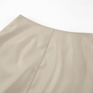 Close-up detail view of khaki PU leather skirt showing fine grain and seam quality