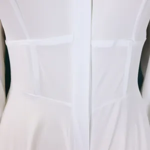 Vista detallada de un elegante vestido camisero blanco con costuras en la cintura