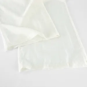 Detailed view of the smooth white Tencel wide-leg trouser hem with fine stitching