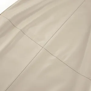 Close-up detail of khaki PU leather skirt showing smooth texture and fine stitching