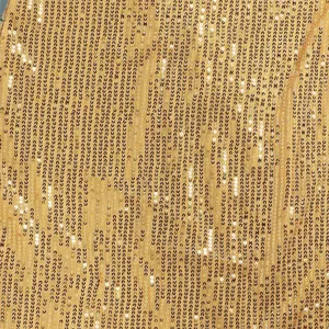 Close-up detail of shimmering gold sequins on a mesh fabric background