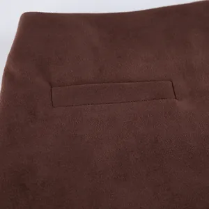 Macro close-up detail of brown suede skirt showing high-quality welt pocket craftsmanship.