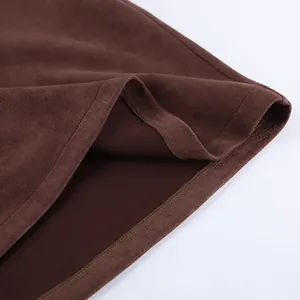Close-up of brown retro suede skirt hem showing fine stitching and soft fabric texture