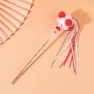 Close-up detail of fairy cat teaser wand with colorful pom-poms and long tassels