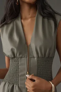Detalle de un vestido retro sin mangas de cuero sintético con cremallera frontal y cintura elástica