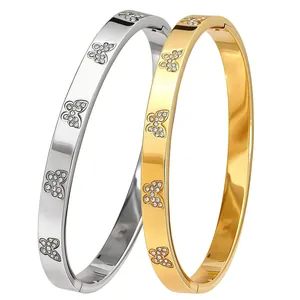 Detailed macro view of polished gold and silver stainless steel crystal butterfly bangles