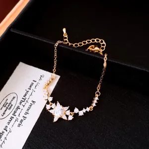 Macro-opname van 18K vergulde armband met zirkonia bloem en een verfijnde schakelketting.
