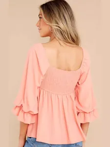 Elegant coral peach square neck blouse with puff mid-sleeves and ruffled smocked back.