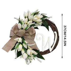 Artificial tulip wreath door decoration with large burlap bow and white letter W detail