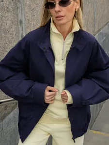 Detail van de navy blauwe oversized katoenen werkjas voor dames met een crèmekleurige outfit.