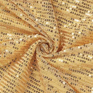 Close-up macro view of shimmering gold sequin fabric for evening party dresses