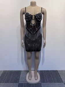 Detailed view of black bodycon mini dress with rhinestones and pearl embellishments