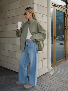 Streetstyle-model met een losse groene katoenen werkjas en een wijde spijkerbroek