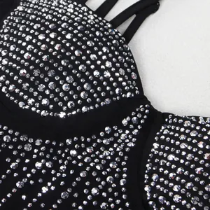 Dettaglio di abito in rete nera con brillanti decorazioni in strass argentati lucidi