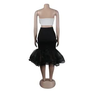 Vista trasera de un conjunto de dos piezas con top bandeau blanco y falda sirena de malla negra