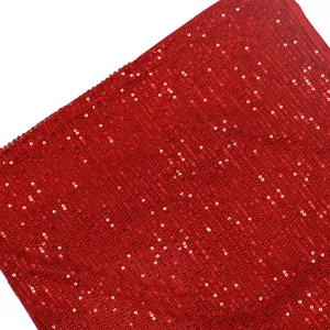 Gros plan sur un tissu à paillettes rouge vif avec un alignement vertical scintillant
