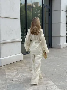 Back view of elegant champagne tencel wrap top and wide-leg trousers set in city street