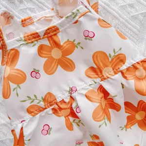 Close-up of orange floral and cherry print on breathable pet summer dress fabric