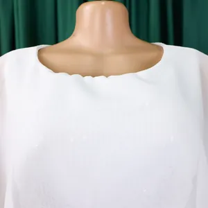 Detailaufnahme eines weißen Chiffon-Abendkleids mit funkelnden Pailletten-Verzierungen