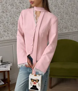 Detail van roze blazer met elegant kant aan de manchetten en kraag gedragen door model