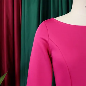 Detail eines fuchsiafarbenen Langarm-Abendkleids mit elegantem Rundhalsausschnitt
