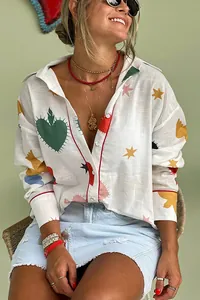 Close-up detail of women's boho long sleeve shirt with colorful heart and star patterns