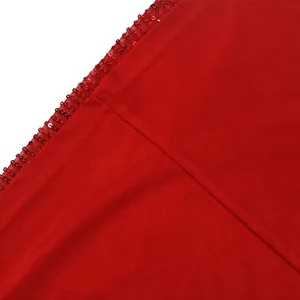 Vue macro détaillée montrant la texture du tissu rouge et les bordures en paillettes