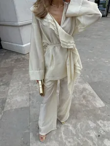 Detailed view of the elegant cream tencel ruffled wrap top and wide-leg trousers set