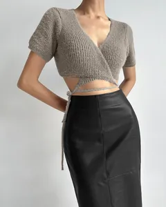 Detail of a chic black PU leather midi pencil skirt paired with a knit wrap top.