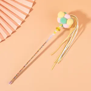 Detailed view of a colorful cat teaser wand with pastel pom-poms and long tassels