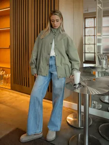Volledig beeld van een saliegroene oversized katoenen utility jas voor modieuze dames