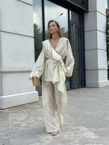 Elegant off-white Tencel two-piece set featuring a ruffled wrap top and wide-leg trousers