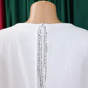 Rückendetail eines weißen Abendkleides aus Chiffon mit Pailletten und Reißverschluss.
