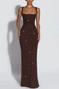 Close-up detail of a sparkling brown sequined floor-length evening gown with thin straps.