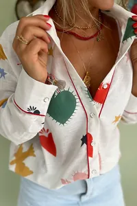 Detailed close-up of a white fashion shirt with colorful heart and bird patterns